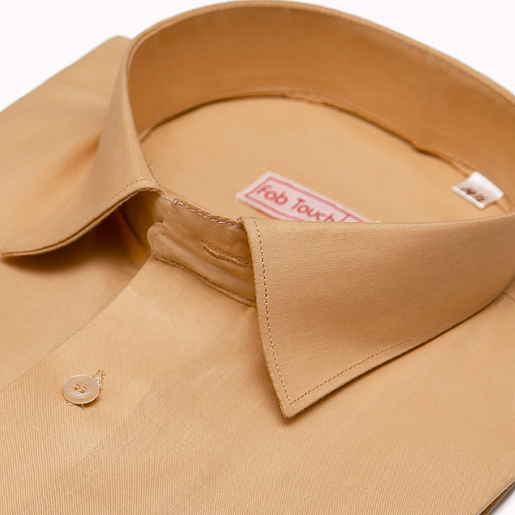 Close-up of a tan men's dress shirt collar and upper chest area, showing a visible Fab Touch brand label inside the collar and a single button on the front placket.